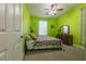 Bedroom with green walls, carpet, bed, and abundant light through the window at 4348 Sw Deepwater Ct, Dunnellon, Fl, FL 34431