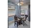 Cozy dining area featuring a glass table, stylish chairs, and a ceiling fan, bathed in natural light from the window at 4348 Sw Deepwater Ct, Dunnellon, Fl, FL 34431