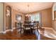 Dining room featuring a dark wood table, chandelier, and natural light from the large window at 4348 Sw Deepwater Ct, Dunnellon, Fl, FL 34431