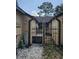 Private courtyard with a black metal gate and white gravel, accessible between two building sections at 611 Water Rd # 103H, Ocala, FL 34472