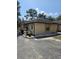 Side exterior view of a tan stucco house with a dark roof and a paved driveway at 611 Water Rd # 103H, Ocala, FL 34472