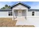 Gray house with a white door and a covered porch at 14293 Sw 32Nd Pl, Ocala, FL 34481