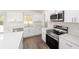 White kitchen with stainless steel appliances and an island at 14293 Sw 32Nd Pl, Ocala, FL 34481