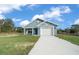 Charming single-story home with a well-manicured lawn, blue paint and a white garage door at 14409 Sw 30Th Pl, Ocala, FL 34481