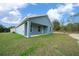 Rear exterior showcasing a covered patio and freshly mowed yard on a house with blue paint and white trim at 14409 Sw 30Th Pl, Ocala, FL 34481