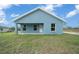 Rear exterior showcasing a covered patio and freshly mowed yard on a house with blue paint and white trim at 14409 Sw 30Th Pl, Ocala, FL 34481