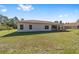 Back view of the home with a covered patio and an expansive green lawn at 14550 Sw 61St Ct, Ocala, FL 34473