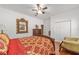 Bright bedroom featuring a large gold mirror, ceiling fan, and wood floors at 14550 Sw 61St Ct, Ocala, FL 34473