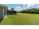 Expansive backyard featuring a screened lanai, lush grass, and mature trees, offering ample space at 25 Nw 45Th Loop, Ocala, FL 34475