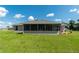 Rear view showcasing the screened lanai, perfect for outdoor relaxation and entertaining with a big yard at 25 Nw 45Th Loop, Ocala, FL 34475