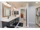 Bathroom with double sinks, dark cabinetry and modern fixtures, featuring walk in closet at 25 Nw 45Th Loop, Ocala, FL 34475