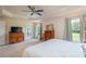 Bright bedroom featuring plush carpeting, tray ceilings, and access to the lanai at 25 Nw 45Th Loop, Ocala, FL 34475