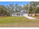 Inviting one-story home with manicured lawn and a paved driveway leading to an attached garage at 13625 Sw 107 Pl, Dunnellon, FL 34432