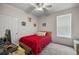 Bedroom with gray carpet, a ceiling fan, a window, and playful dog art on the walls at 4560 Sw 52Nd Cir # 101, Ocala, FL 34474