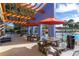 Outdoor seating area with picnic tables and umbrellas next to the pool at 4560 Sw 52Nd Cir # 101, Ocala, FL 34474