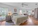Relaxing main bedroom with ceiling fan, natural light, and wood flooring at 10716 Sw 53Rd Cir, Ocala, FL 34476