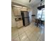 Kitchen boasts stainless steel refrigerator, adjacent eating area and tile flooring throughout at 11696 Sw 71St Cir, Ocala, FL 34476