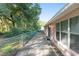 A view of the patio, with mature trees and greenery visible beyond the chain link fence at 11696 Sw 71St Cir, Ocala, FL 34476