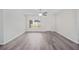 Bright living room featuring neutral walls, wood-look flooring, a modern ceiling fan, and natural light at 24381 Nw Falcon Ave, Dunnellon, FL 34432