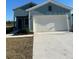 Charming two-story home featuring light blue siding, an attached two-car garage, and manicured front lawn at 1223 Nw 44Th Court Rd, Ocala, FL 34482