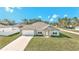 Tan one-story house with white garage door and shutters, and a green lawn at 4414 Sw 170Th Street Rd, Ocala, FL 34473