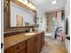 Full bathroom with a granite countertop, dark wood vanity, tub-shower combo, and decorative mirror at 2818 Se 24Th Ave, Ocala, FL 34471