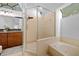 Elegant bathroom featuring a glass-enclosed shower, soaking tub, dark wood cabinetry, and a large arched window at 2818 Se 24Th Ave, Ocala, FL 34471