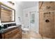 Bathroom featuring a dark vanity with a walk-in shower and access to a backyard space at 2818 Se 24Th Ave, Ocala, FL 34471