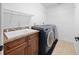 Well-equipped laundry room featuring a utility sink, wooden cabinets, and modern washer and dryer set at 2818 Se 24Th Ave, Ocala, FL 34471