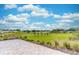 Scenic backyard view, showcasing a paver patio, manicured lawn, and vibrant blue skies with puffy clouds at 9994 Sw 96Th St, Ocala, FL 34481