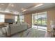 Living room showcasing a large TV, plush seating, and sliding glass doors to a patio at 9994 Sw 96Th St, Ocala, FL 34481