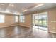 Living room with wood floors and sliding glass doors leading to the outdoor patio at 9994 Sw 96Th St, Ocala, FL 34481