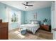 Bedroom with light blue walls, ceiling fan, and wood floors at 9459 Sw 52Nd Loop, Ocala, FL 34481