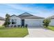 One-story home with gray roof and light blue exterior, landscaping, and driveway at 9459 Sw 52Nd Loop, Ocala, FL 34481