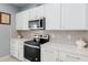 Modern kitchen with white cabinets, stainless steel appliances, and quartz countertops at 9459 Sw 52Nd Loop, Ocala, FL 34481