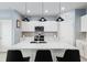 White kitchen with quartz island, stainless steel appliances, and pendant lighting at 9459 Sw 52Nd Loop, Ocala, FL 34481