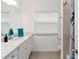 Bathroom with white vanity, window, and shower/tub at 7531 Sw 77Th Ave, Ocala, FL 34481