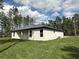 Backyard features a well maintained lawn, simple siding, and a patio area perfect for outdoor activities at 13374 Sw 63Rd Ter, Ocala, FL 34473