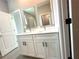 A bright bathroom vanity featuring double sinks, undermount lighting, and stylish cabinets at 13374 Sw 63Rd Ter, Ocala, FL 34473