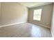 Bright, minimalist bedroom with wood-look tile and a large window at 13374 Sw 63Rd Ter, Ocala, FL 34473