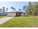 New construction home with manicured lawn, a two-car garage, and inviting front entrance at 13374 Sw 63Rd Ter, Ocala, FL 34473
