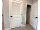 Hallway closet with white shelving, next to a louvered door for ventilation at 13374 Sw 63Rd Ter, Ocala, FL 34473