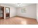 Simple bedroom with wood floors and a window, leading to ensuite bathroom at 5721 Se 22Nd Pl, Ocala, FL 34480