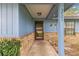 Covered front porch with brick base and blue siding, featuring front door and house number at 5721 Se 22Nd Pl, Ocala, FL 34480