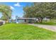 Exterior shot of single story home with brick and blue painted siding and large oak trees in front at 5721 Se 22Nd Pl, Ocala, FL 34480