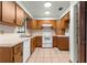 Traditional kitchen with wood cabinets, white appliances, and tile flooring at 5721 Se 22Nd Pl, Ocala, FL 34480