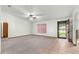 Living room featuring a window, ceiling fan, and view of the front door at 5721 Se 22Nd Pl, Ocala, FL 34480