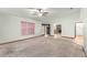 Living room with a window, ceiling fan, and view into another room with a brick fireplace at 5721 Se 22Nd Pl, Ocala, FL 34480