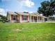 Tan house with red shutters, front porch, and spacious lawn at 8981 Sw 116Th Place Rd, Ocala, FL 34481