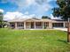 Tan house with red shutters, front porch, and large lawn at 8981 Sw 116Th Place Rd, Ocala, FL 34481